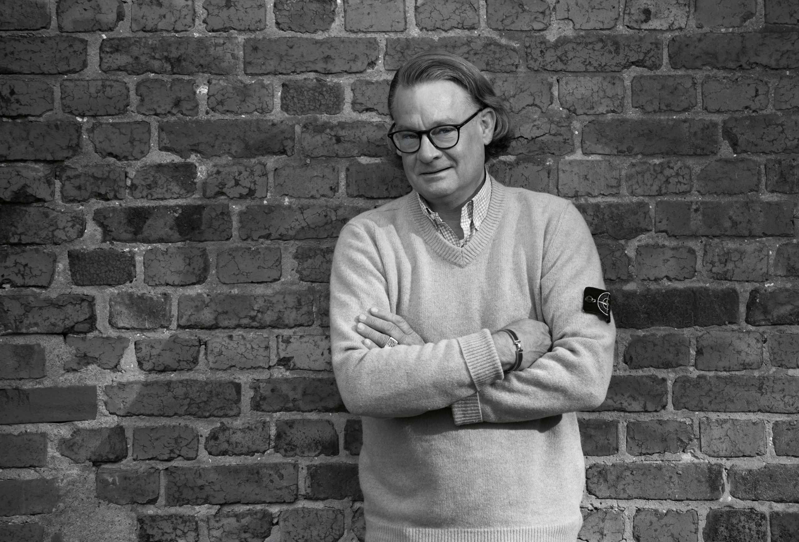 Anwalt Stefan Gelhaus mit verschränkten Armen schwarz-weiß Bild vor Steinwand