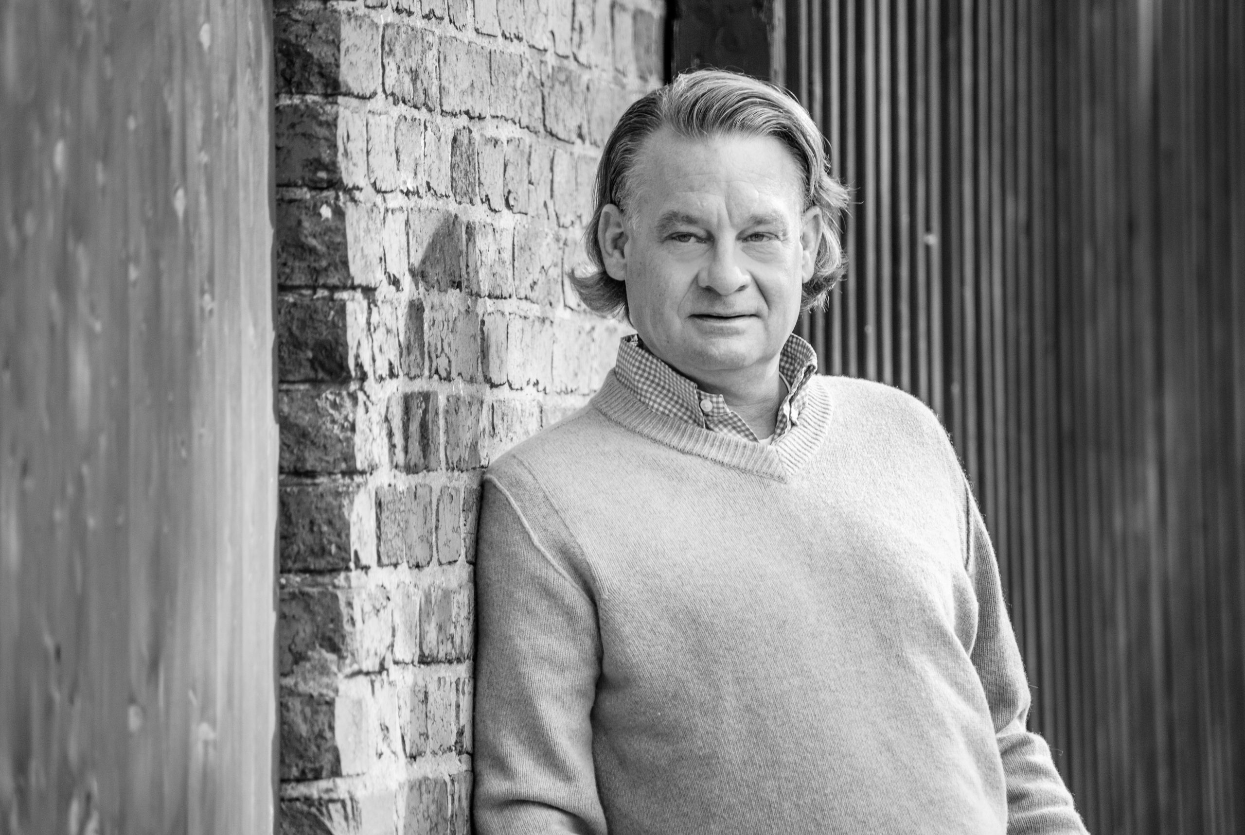 Stefan Gelhaus angelehnt an Wand Anwalt für Arbeitsrecht Stefan Gelhaus lehnt an einer Wand, schwarz-weiß Bild